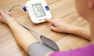 A person is using a home blood pressure monitor to check their blood pressure.